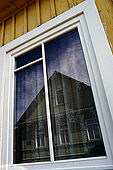 Trakai, Lithuania. A typical karaim house reflecting on window of another karaim house in Karaimu gatvè (Karaims street)  