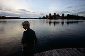 Trakai, Lithuania: a boy fishing in the Galves lake at dusk; 