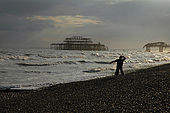 Boy throwing a stone into the sea on Brighton beach