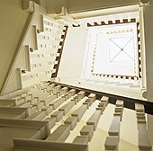 Above view of a winding staircase with a glass skylight at the top,
