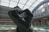 England, London, St Pancras Station. A statue of poet John Betjeman by Martin Jennings / ADAGP, at St. Pancras International station, with the famous clock in the background.