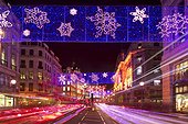England, London, Regent Street. Light rails from traffic as it passes along Regent Street under the annual Christmas lights.