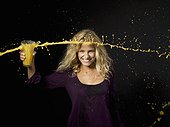 Woman throwing orange juice from a glass