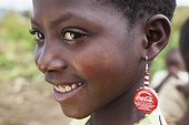 A Girl Wearing Coca-Cola Bottle Cap Earrings; Manica, Mozambique, Africa