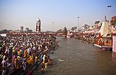 a crowd gathers to bathe at the ganges river for the kumbh mela pilgrimage; haridwar india