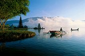 Indonesia, Bali, Ulu Danu temple at sunrise, small boats on water, fog