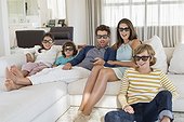 Famille qui regarde la télévision à la maison avec des lunettes 3D